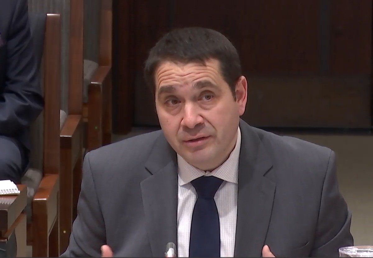 Antonio Utano at the committee table, mid-answer